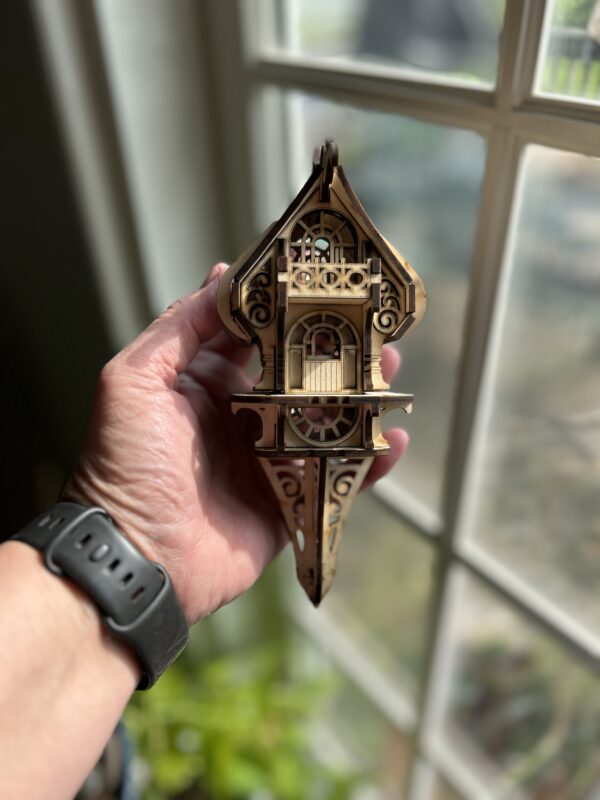 Assembled DIY fairy and elf house kit made from 3mm basswood, displayed in a garden planter with whimsical fairy decor